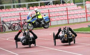 uczestnicy biegu na wózkach i widok na patrol