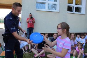 policjant wręcza dzieciom upominki