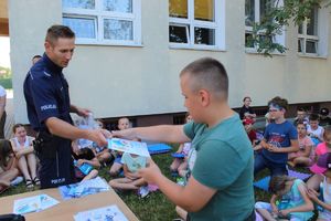 chłopiec odbiera od policjanta gadżet