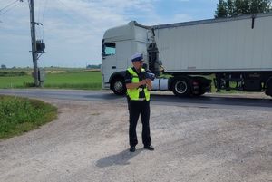 policjant z miernikiem na tle ciężarówki