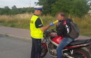 policjant stoi przy motocykliście