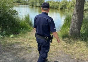 pplicjant dokonuje obchodu nad wodą