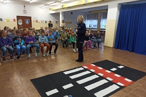 Dzieci wraz z opiekunami oraz policjantka.