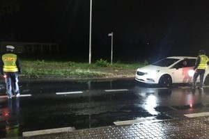 Dwóch policjantów oraz pojazd, którego kierowca jest kontrolowany na trzeźwość.