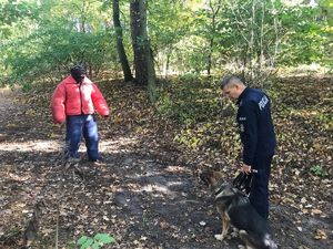 Pies służbowy z przewodnikiem  oraz pozorant w specjalnym stroju.