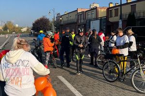 policjanci wręczają taśmy odblaskowe