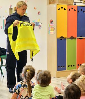 policjantka pokazuje kamizelkę odblaskową