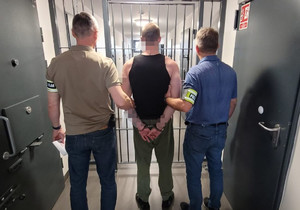 zatrzymany stoi z policjantami