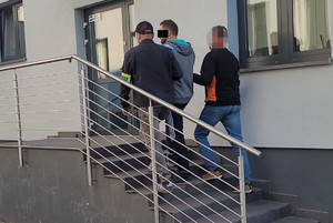 policjanci prowadza zatrzymanego