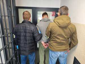 policjanci trzymają zatrzymanego