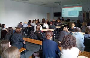 Słuchacze siedzią w ławkach w dużej sali na wykładzie policjantów