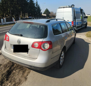 na poboczu stoi srebrny VW Passat, a przed nim radiowóz policyjny