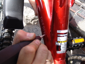 na zdjęciu widać dłoń z urządzeniem grawer oraz ramę roweru