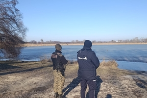 Policja i Straż Rybacka stojący na brzegu jeziora