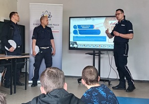Zdjęcia przedstawiające policjantów i ratowników WOPR na spotkaniu z młodzieżą. W tle prezentacja, symulatory i sprzęt do ratownictwa.
