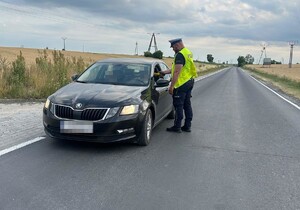 Policjant ruchu drogowego kontroluje trzeźwość kierowcy