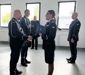 Policjanci w mundurach galowych. Nadkomisarz Paweł Mróz i podinspektor Michał Puszczykowski otrzymują rozkazy dotyczące ich awansów.