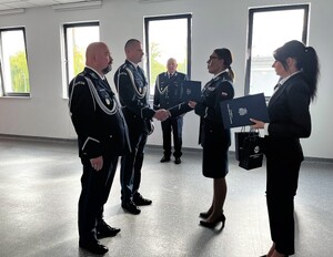 Policjanci w mundurach galowych. Nadkomisarz Paweł Mróz i podinspektor Michał Puszczykowski otrzymują rozkazy dotyczące ich awansów.