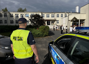 umundurowany policjant pilnuje bezpieczeństwa przed szkołą
