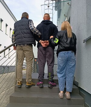 Policjanci prowadzą, zatrzymanego, który dokonał uszkodzenia ciała w dniu 13.09.2026