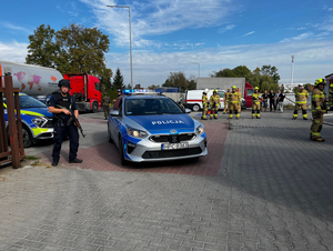 Podczas ćwiczeń: policjanci umundurowani,  długą bronią i w kamizelkach kuloodpornych przy oznakowanym radiowozie